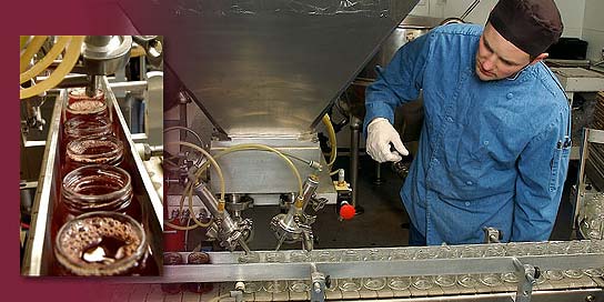 Photo of sauce being deposited into jars in an Alaska Wild Berry Candy Kitchen